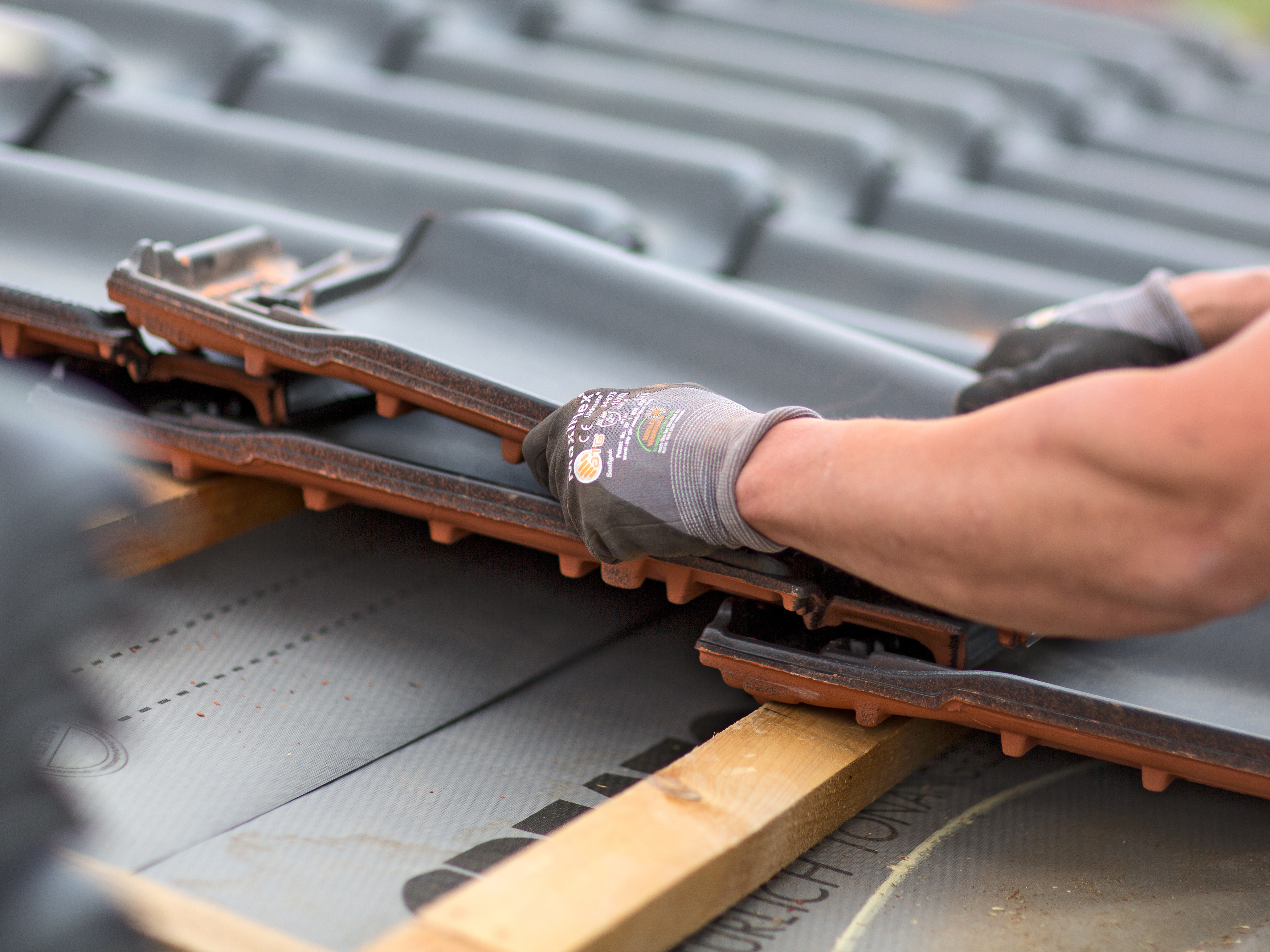 Roofer covers tile on the roof